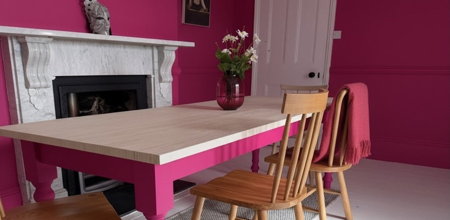 A wooden table with pink legs in a pink room. 