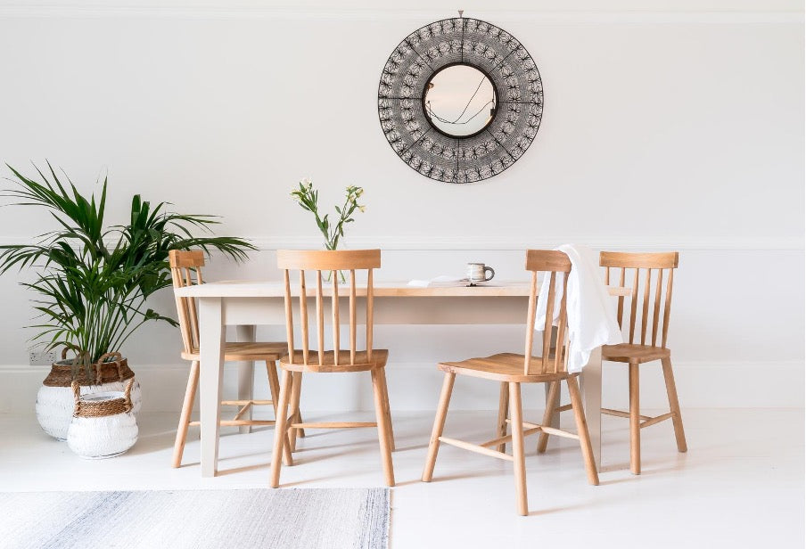A Skandi table with beige legs in a white room.