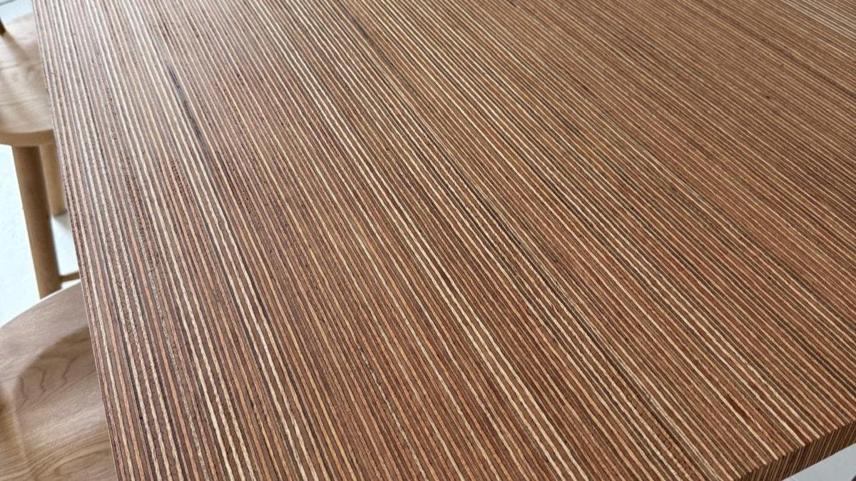 Close up of wooden dining table top in ply wood with stain finish